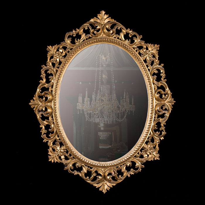 An oval gilded Rococo style wall mirror
